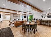 Thumbnail 47 of 136 - a living room with a table and chairs and a kitchen at The Flats at Riverwoods, Provo