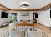 Thumbnail 61 of 136 - a living room with a fireplace and a table and chairs at The Flats at Riverwoods, Provo, 84604