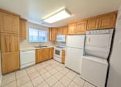 Thumbnail 2 of 14 - A kitchen with wooden cabinets and white appliances.