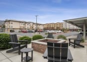 Thumbnail 20 of 50 - a patio with chairs and a firepit at the whispering winds apartments in pearland, tx at The View on 20th, Ogden, Utah