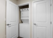 Thumbnail 121 of 136 - a pantry with white doors and a white stove and dishwasher at The Flats at Riverwoods, Provo, UT, 84604
