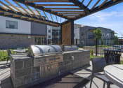 Thumbnail 101 of 136 - a patio with a grill and tables and chairs at The Flats at Riverwoods, Provo, Utah