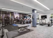 Thumbnail 76 of 136 - a spacious fitness room with cardio equipment and a flat screen tv at The Flats at Riverwoods, Utah, 84604
