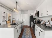 Thumbnail 64 of 84 - a large kitchen with black counters and white cabinets at The Revival, Salt Lake City, UT