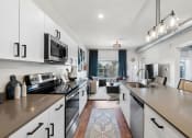 Thumbnail 66 of 84 - an open kitchen with counters and appliances and a living room at The Revival, Salt Lake City, 84101
