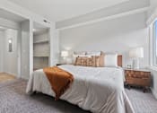 Thumbnail 19 of 71 - A bedroom with a large bed and a wooden end table at Wilmington Flats Apartments, Utah, 84106