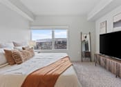 Thumbnail 21 of 71 - A bedroom with a large bed and a flat screen TV at Wilmington Flats Apartments, Utah, 84106