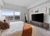 Thumbnail 18 of 71 - A bedroom with a large bed and a television at Wilmington Flats Apartments, Utah