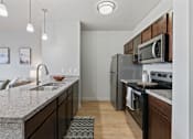 Thumbnail 10 of 71 - A kitchen with a granite countertop and stainless steel appliances at Wilmington Flats Apartments, Salt Lake City, 84106