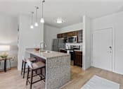 Thumbnail 9 of 71 - A kitchen with a bar area and a refrigerator at Wilmington Flats Apartments, Salt Lake City, UT, 84106