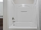 Thumbnail 25 of 71 - A white bathroom with a tub and a shower at Wilmington Flats Apartments, Utah