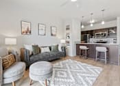 Thumbnail 2 of 71 - A modern living room with a grey couch, a grey ottoman, and a grey rug at Wilmington Flats Apartments, Salt Lake City, 84106