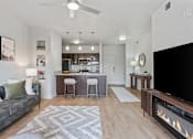 Thumbnail 8 of 71 - A modern living room with a grey couch and a fireplace at Wilmington Flats Apartments, Salt Lake City