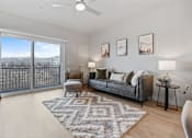 Thumbnail 16 of 71 - A living room with a grey couch, a rug, and pictures on the wall at Wilmington Flats Apartments, Salt Lake City, UT