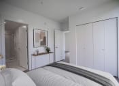 Thumbnail 10 of 22 - a bedroom with white walls and a white bed with a grey blanket and a big closet