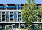 Thumbnail 23 of 28 - A modern building with a tree in front of it.