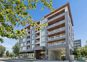 Thumbnail 25 of 28 - A modern multi-story building with a parking garage underneath.