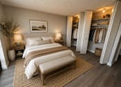 Thumbnail 5 of 17 - A bedroom with a large bed and a bench in the middle of the room.