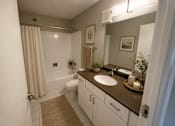 Thumbnail 6 of 17 - A bathroom with a toilet, sink, and shower.