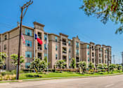 Thumbnail 12 of 27 - A row of apartment buildings with a clear blue sky above. at Atlas Point at Prestonwood Apartments , Carrollton