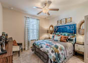Thumbnail 25 of 27 - A bedroom with a bed, a chair, a nightstand, and a ceiling fan at Atlas Point at Prestonwood Apartments , Texas