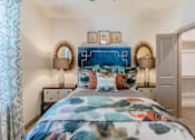 Thumbnail 24 of 27 - A bedroom with a large bed and a blue headboard at Atlas Point at Prestonwood Apartments , Carrollton, Texas