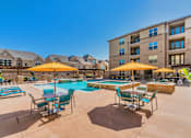 Thumbnail 3 of 27 - A large outdoor pool area with sun loungers and umbrellas. at Atlas Point at Prestonwood Apartments , Carrollton
