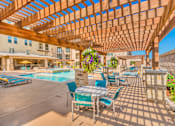 Thumbnail 5 of 27 - A wooden pergola over a poolside seating area at Atlas Point at Prestonwood Apartments , Carrollton, TX, 75010