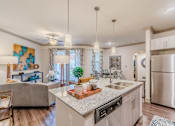 Thumbnail 18 of 27 - A modern kitchen with a large island and stainless steel appliances at Atlas Point at Prestonwood Apartments , Carrollton, TX, 75010