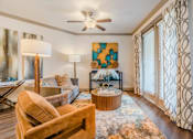 Thumbnail 23 of 27 - A living room with a brown chair and a painting on the wall. at Atlas Point at Prestonwood Apartments , Carrollton, Texas