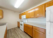 Thumbnail 24 of 28 - A kitchen with wooden cabinets and white appliances.