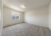 Thumbnail 20 of 28 - A room with a carpeted floor and a window.
