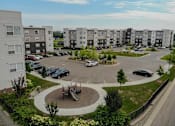 Thumbnail 1 of 21 - an aerial view of an apartment complex with cars in a parking lot