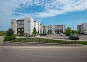 Thumbnail 3 of 21 - A large apartment complex with a playground in the front.