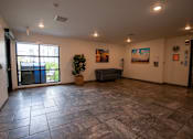 Thumbnail 7 of 21 - a large living room with a sliding glass door and tile floors
