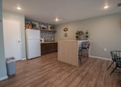 Thumbnail 8 of 21 - a kitchen and dining area with a refrigerator and a table and chairs