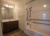 Thumbnail 20 of 21 - A bathroom with a white tub and a white sink.