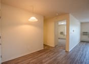Thumbnail 10 of 11 - an empty living room and hallway with wood flooring and a ceiling light