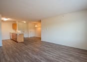 Thumbnail 6 of 11 - an empty living room and kitchen with wood flooring and white walls