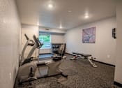 Thumbnail 3 of 12 - A gym room with treadmills, exercise bikes, and a television.