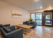 Thumbnail 8 of 12 - A room with a painting on the wall and a table with chairs.