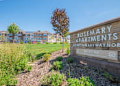Thumbnail 1 of 8 - A sign for Rosemary Apartments is in front of a grassy area.