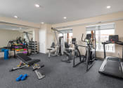 Thumbnail 16 of 21 - a gym with treadmills and other exercise equipment in a room with windows