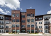 Thumbnail 33 of 52 - an exterior view of an apartment building with stone and brown exterior walls