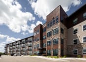 Thumbnail 34 of 52 - an exterior view of a building with cars parked in front of it