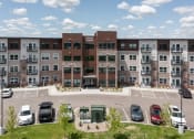 Thumbnail 17 of 52 - an aerial view of an apartment building with parking lot and cars