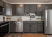 Thumbnail 44 of 52 - a kitchen with stainless steel appliances and gray cabinets