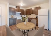 Thumbnail 16 of 21 - a kitchen and dining area with a table and chairs and a refrigerator
