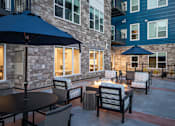 Thumbnail 13 of 19 - A patio with a table and chairs and umbrellas.
