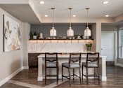 Thumbnail 16 of 19 - A kitchen with a marble countertop and wooden chairs.